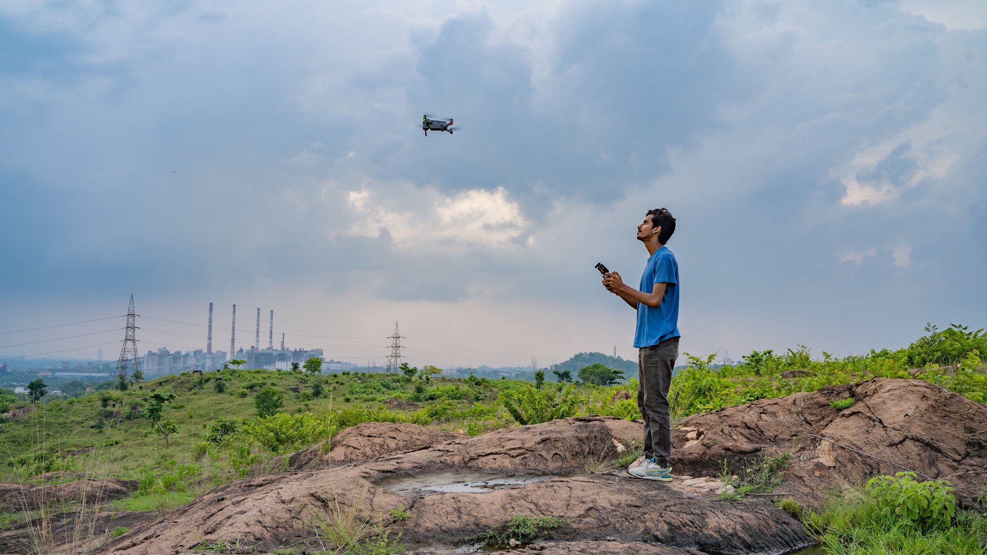 Young man flying drone, unmanned aerial vehicle, photographer, filmmaker or content creator concept